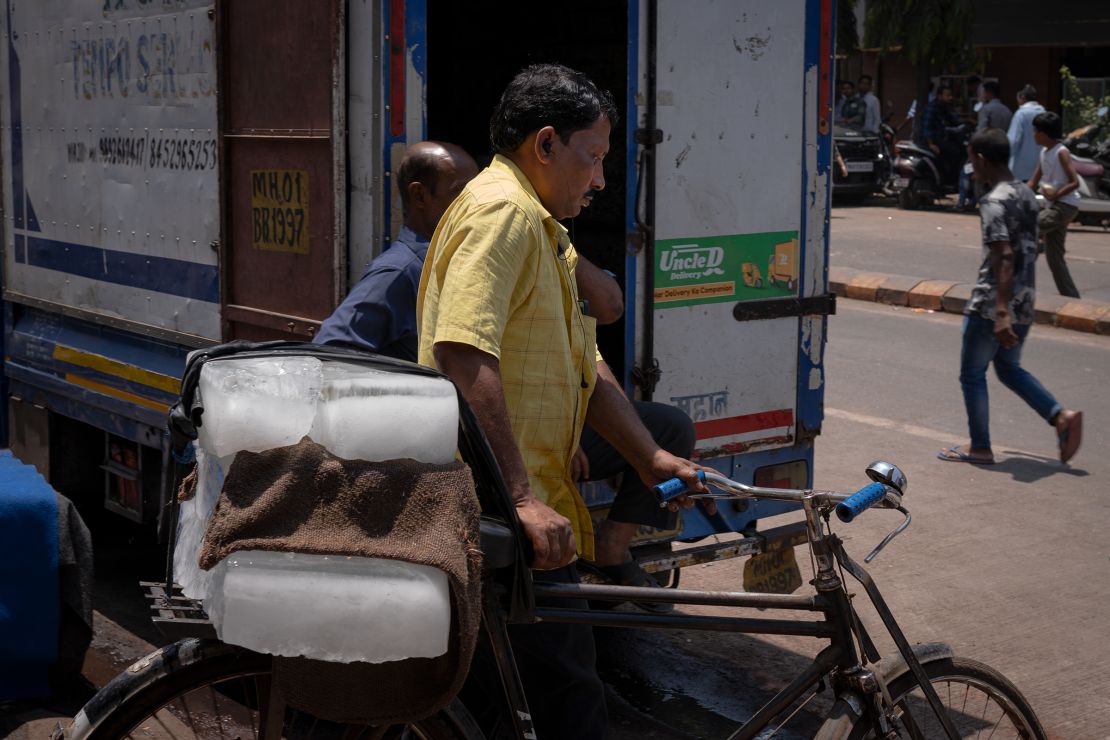 A man carries ice on his bicycle in Mumbai, India on Sunday, April 14, 2024.