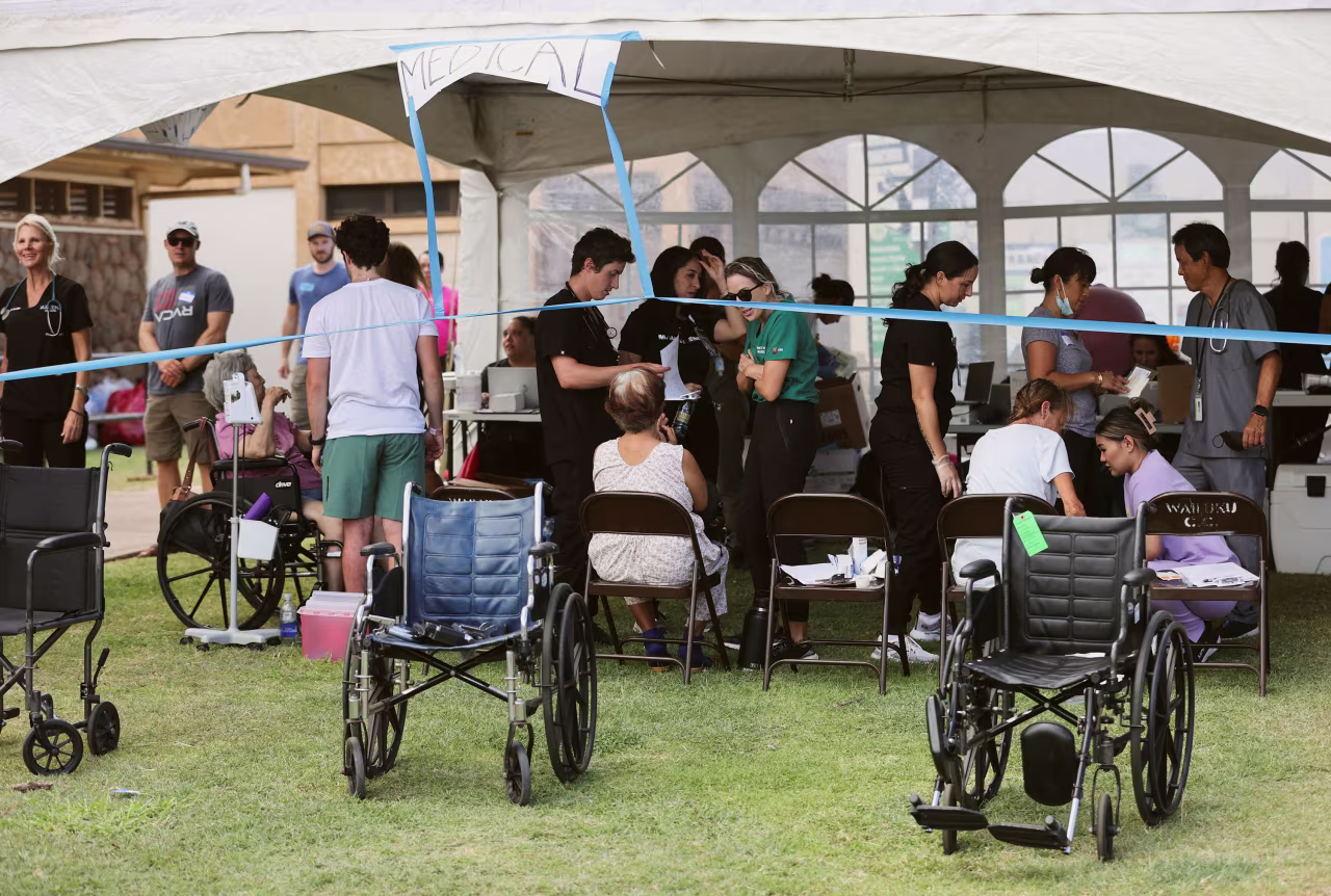 Volunteers attend to evacuees from the West Maui wildfires at a shelter set up at the Maui War Memorial in Wailuku, Hawaii, on August 10, 2023.