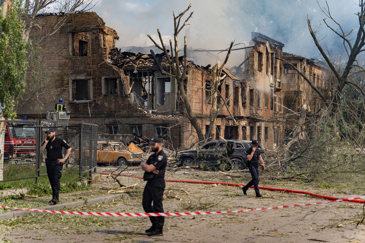 Police officers stand near the site of a missile strike on a hospital, fenced by warning tape on May 26, in Dnipro, Ukraine.?