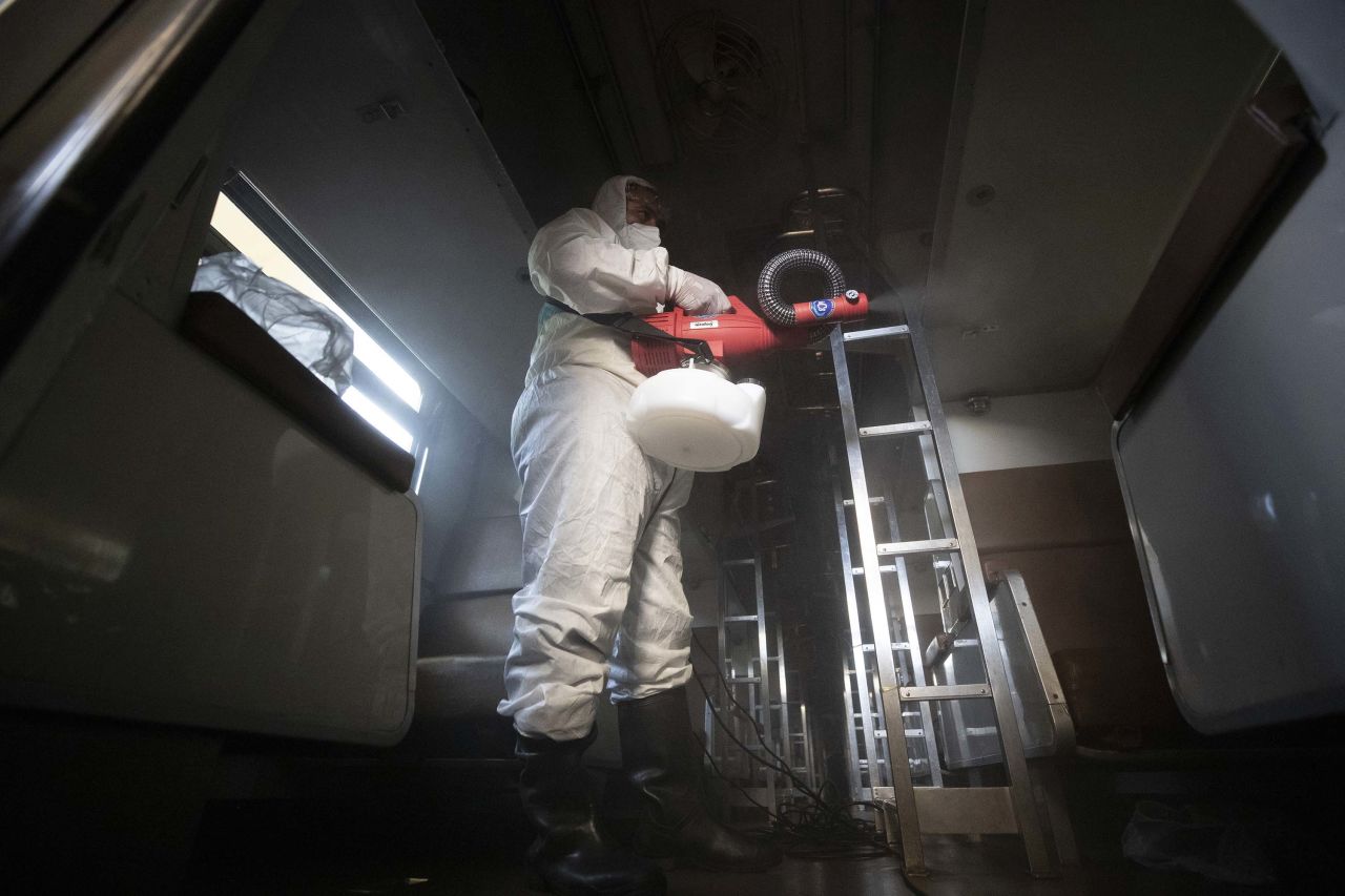 A worker disinfects a train in effort to prevent the spread of the coronavirus, at Hua Lamphong Railway Station in Bangkok, Thailand, on Friday.