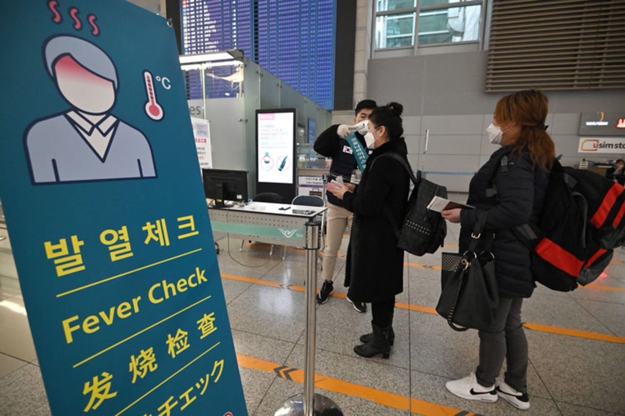 A member of the South Korean military support team checks the body temperature of a passenger at a gate in the departure hall at Incheon international airport, west of Seoul, on March 17.