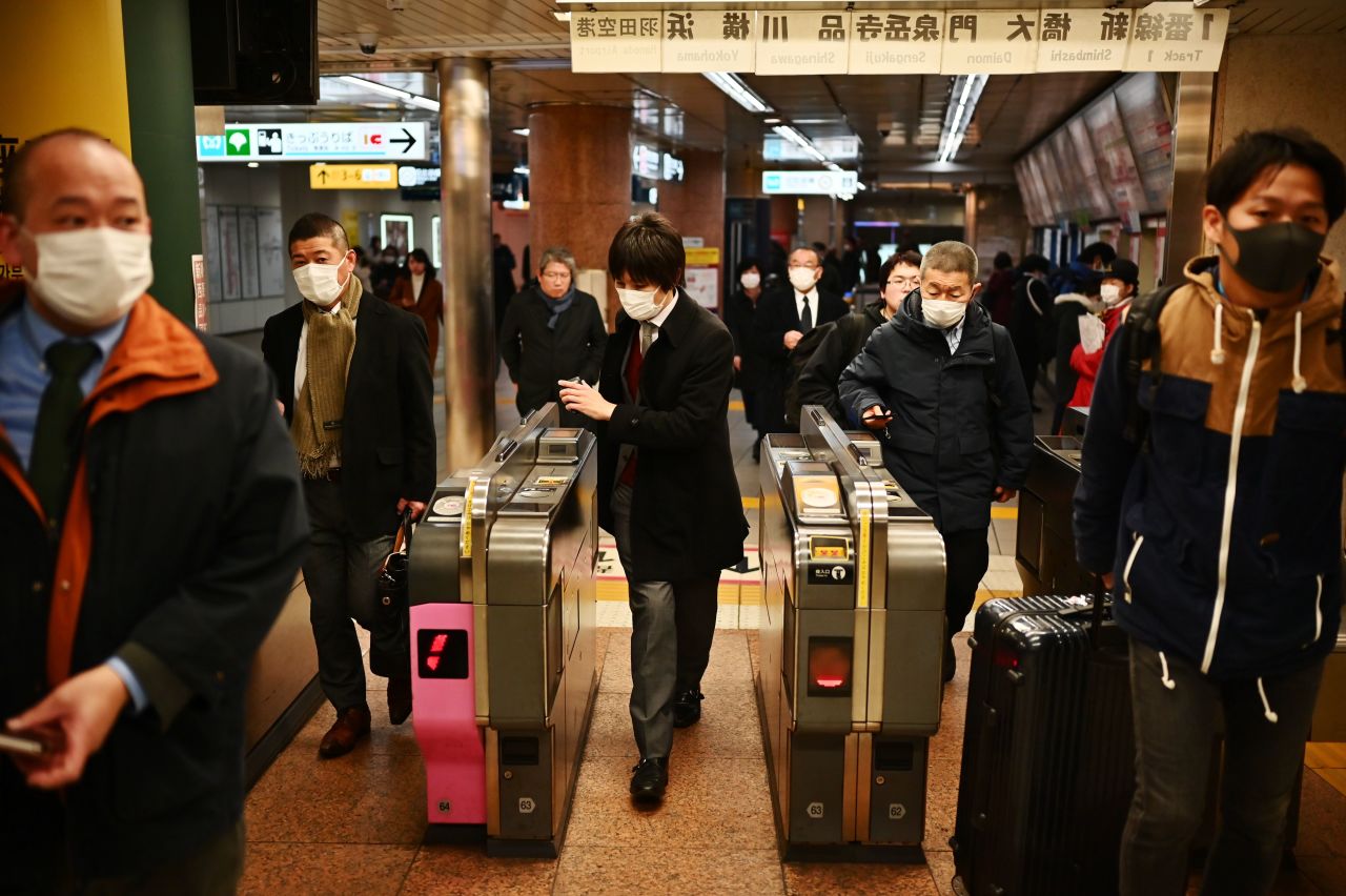 Commuters pass through a train station in Tokyo's Ginza district on February 17, 2020. 