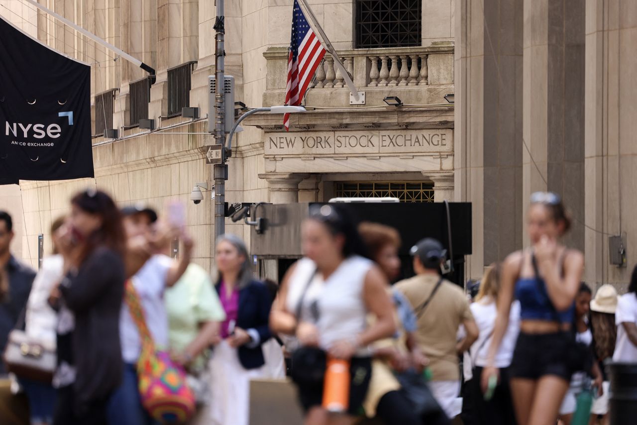 People walk by the New York Stock Exchange in the Financial District in New York City on August 5.