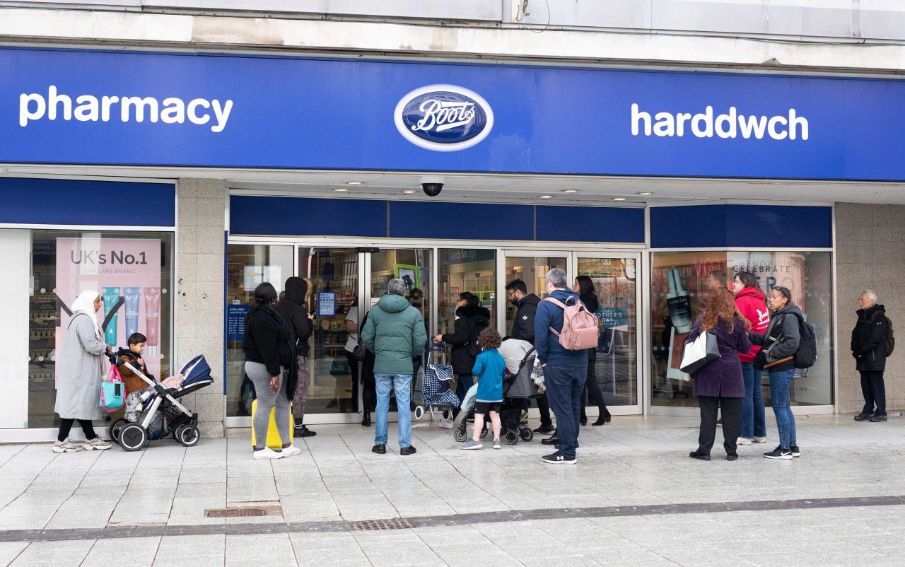 Shoppers wait for a Boots pharmacy store to open on March 8, in Cardiff, Wales.