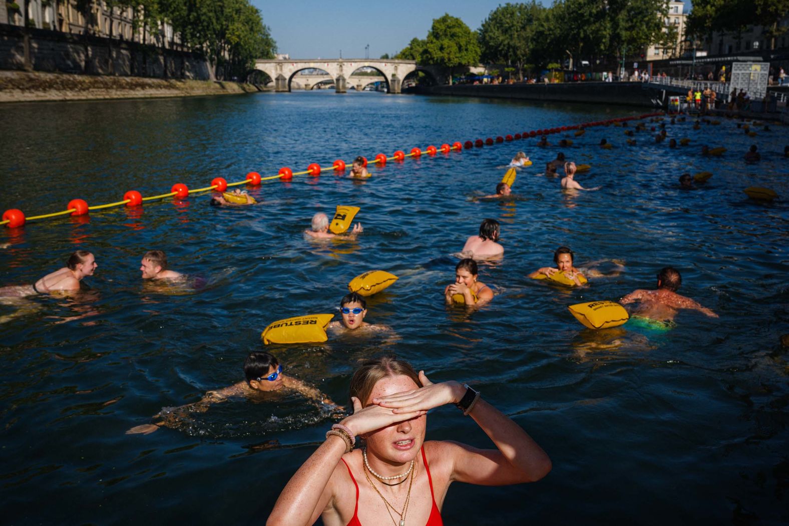People swim at the Bras Marie safe bathing site in the River Seine in Paris on Tuesday, August 12.