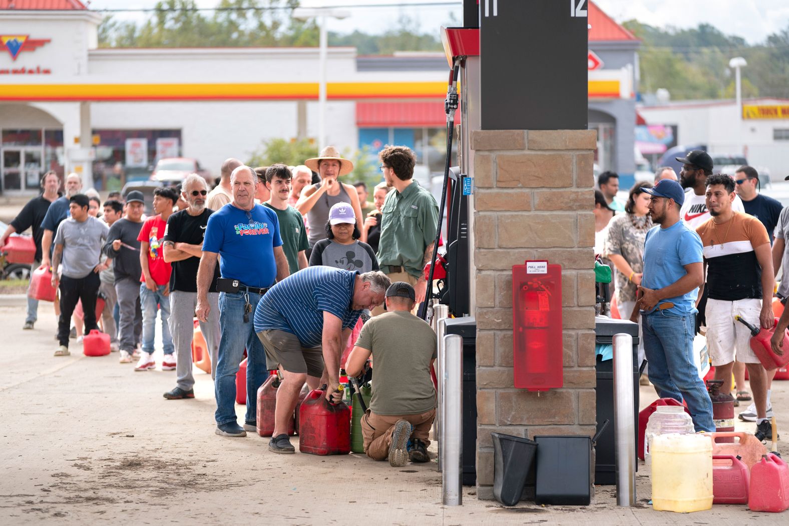 People wait in line to access gasoline in Fletcher, North Carolina, on Sunday.