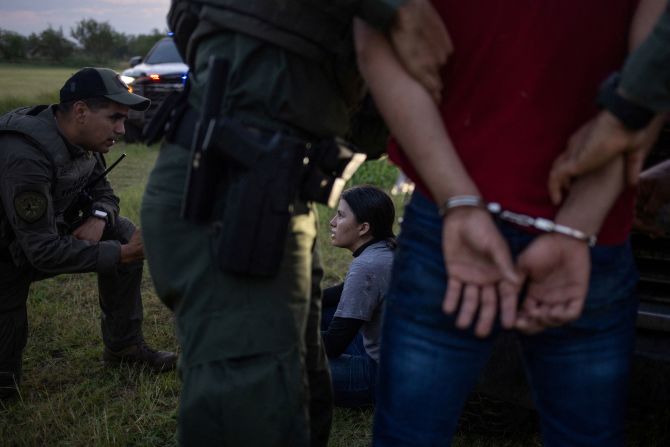 Texas State Trooper Guadalupe Casarez questions a migrant from El Salvador after she and others crossed into the United States from Mexico on Thursday, June 13.