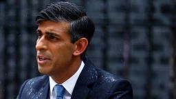 Britain's Prime Minister Rishi Sunak, soaked in rain, pauses as he delivers a speech to announce July 4 as the date of the UK's next general election, at 10 Downing Street in central London on May 22, 2024.