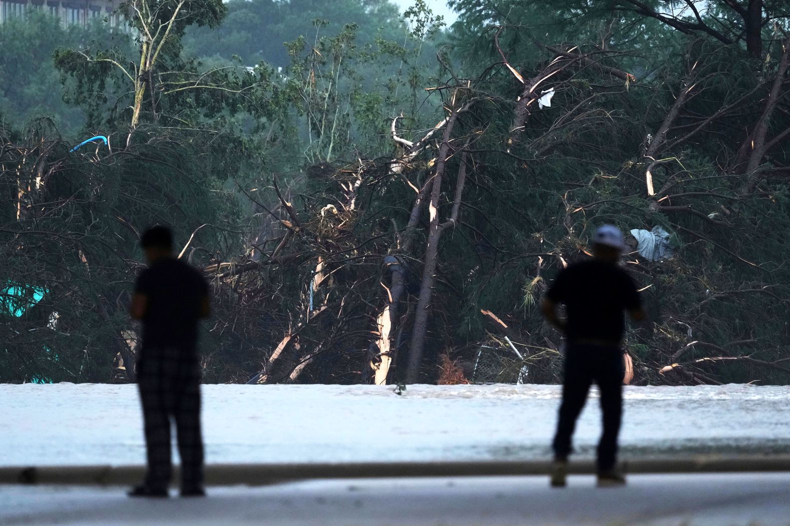 People observe damage caused along the Guadalupe River in Kerrville.