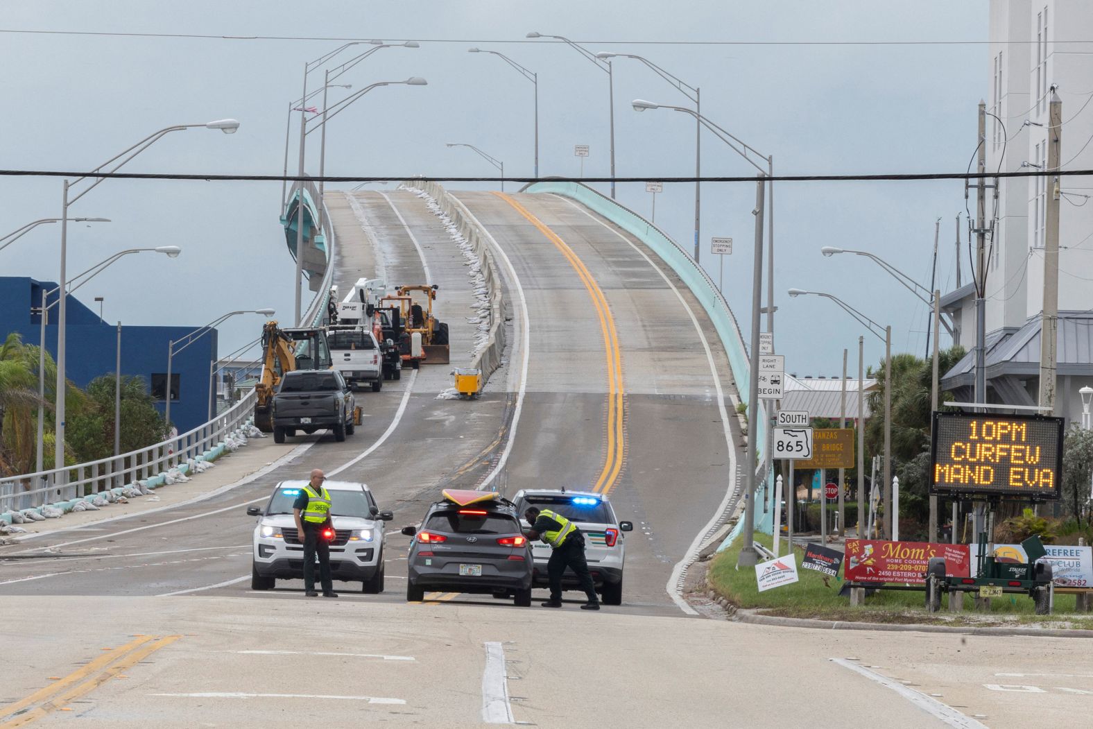 A Lee County deputy sheriff talks to a driver near the Fort Myers Beach bridge, which was closed on Wednesday.