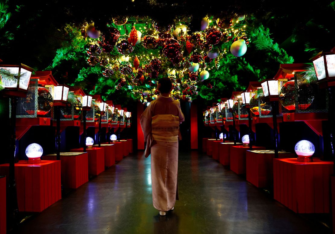A visitor looks at a Christmas installation with goldfish and colorful lights at Tokyo's Art Aquarium Museum.
