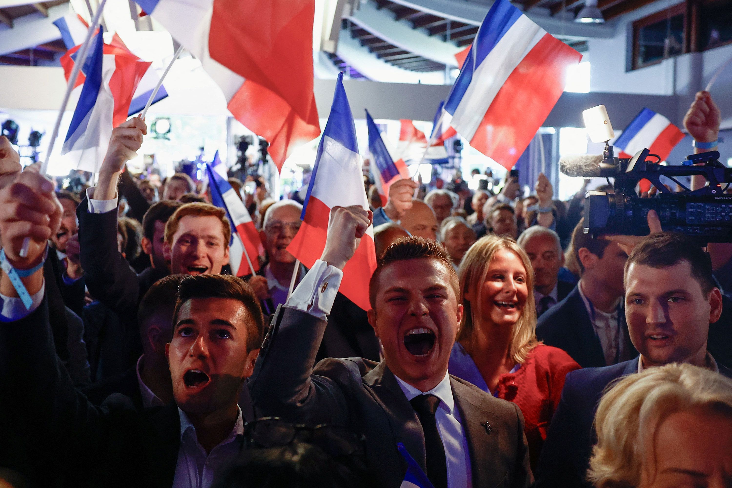 Supporters of the far-right National Rally party react in Paris after polls closed in European parliamentary elections on Sunday, June 9.