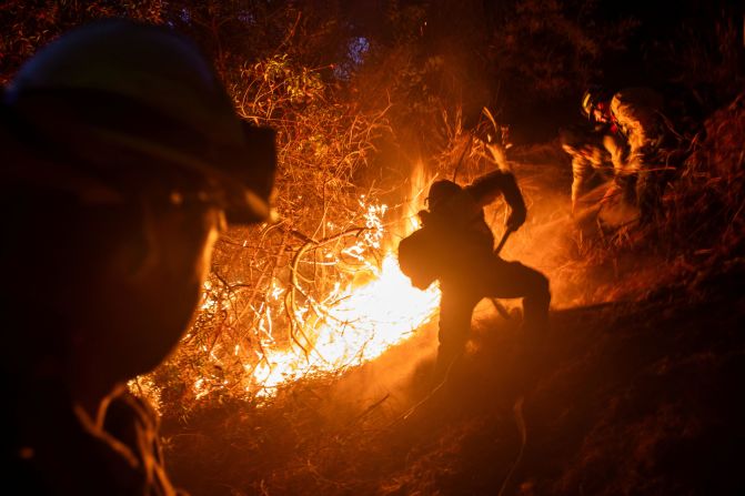 Firefighters battle the Palisades Fire in the Mandeville Canyon neighborhood of Los Angeles on Sunday, January 12.