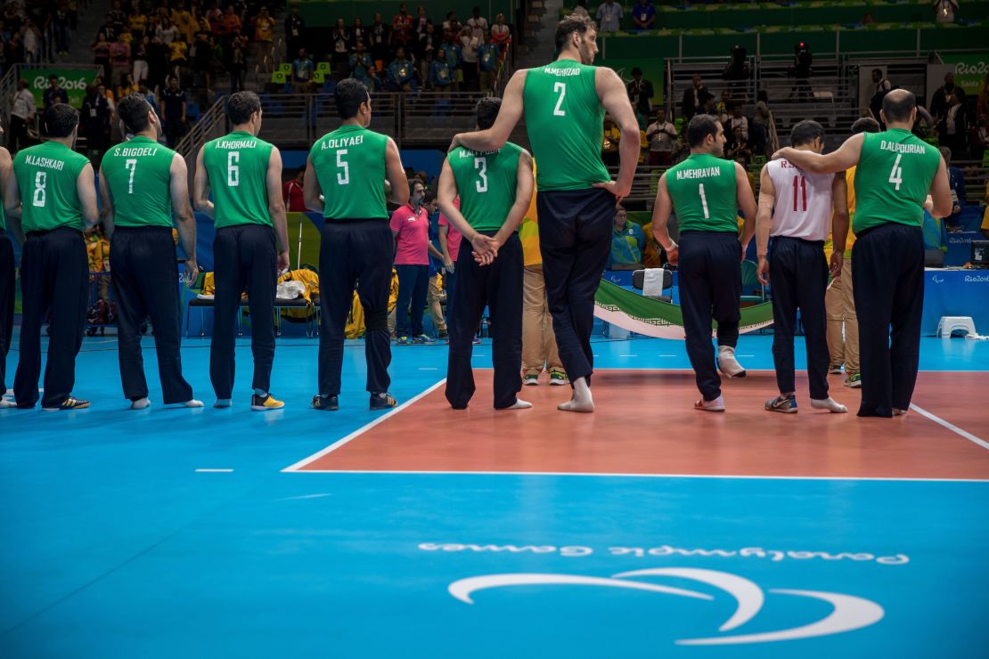 Mehrzad (No. 2) se encuentra con sus compañeros de equipo iraníes durante la interpretación del himno de su nación antes de la semifinal de voleibol sentado masculino con Brasil en los Juegos Paralímpicos de 2016 en Río de Janeiro.