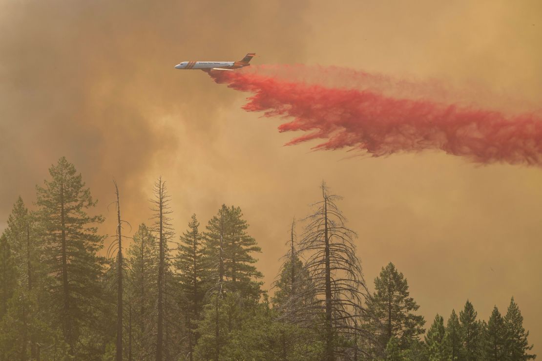 A plane drops fire retardant on the Park Fire Sunday near Forest Ranch, California.