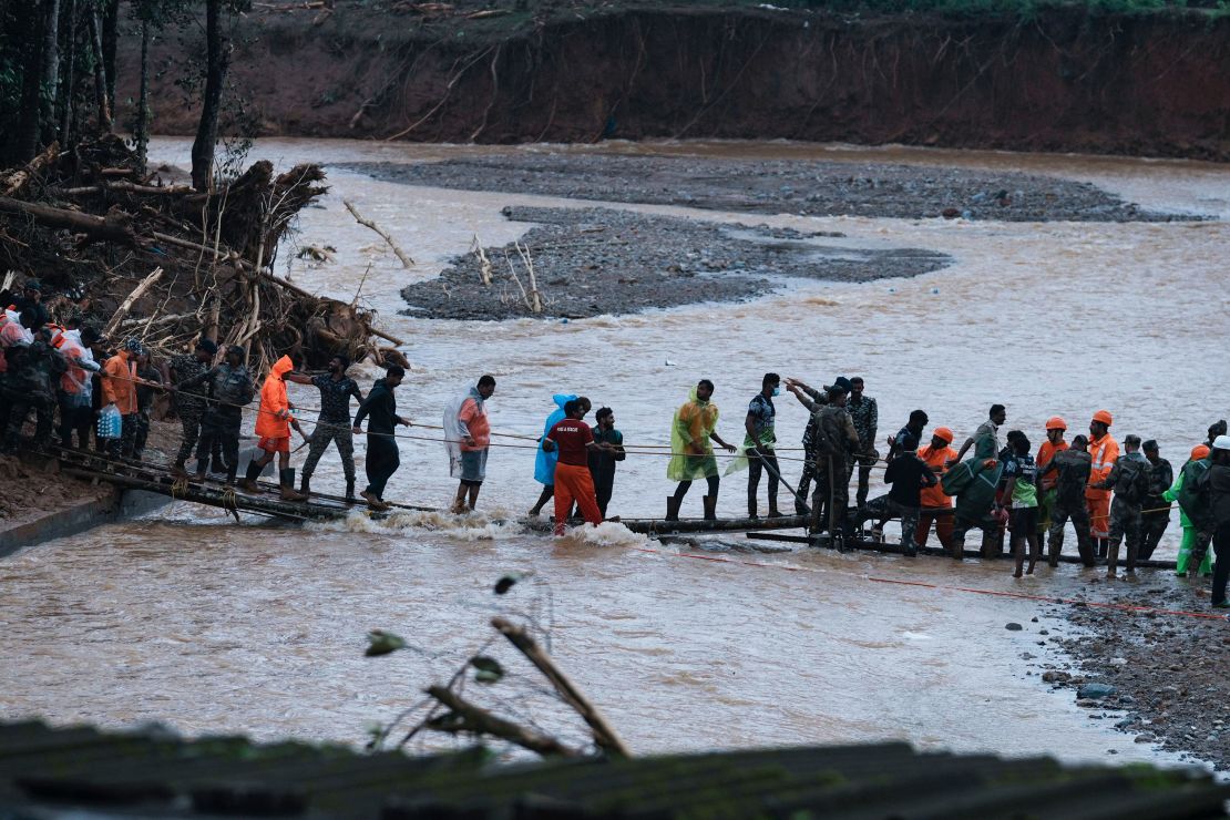 Rescuers use a temporary bridge to cross a river.