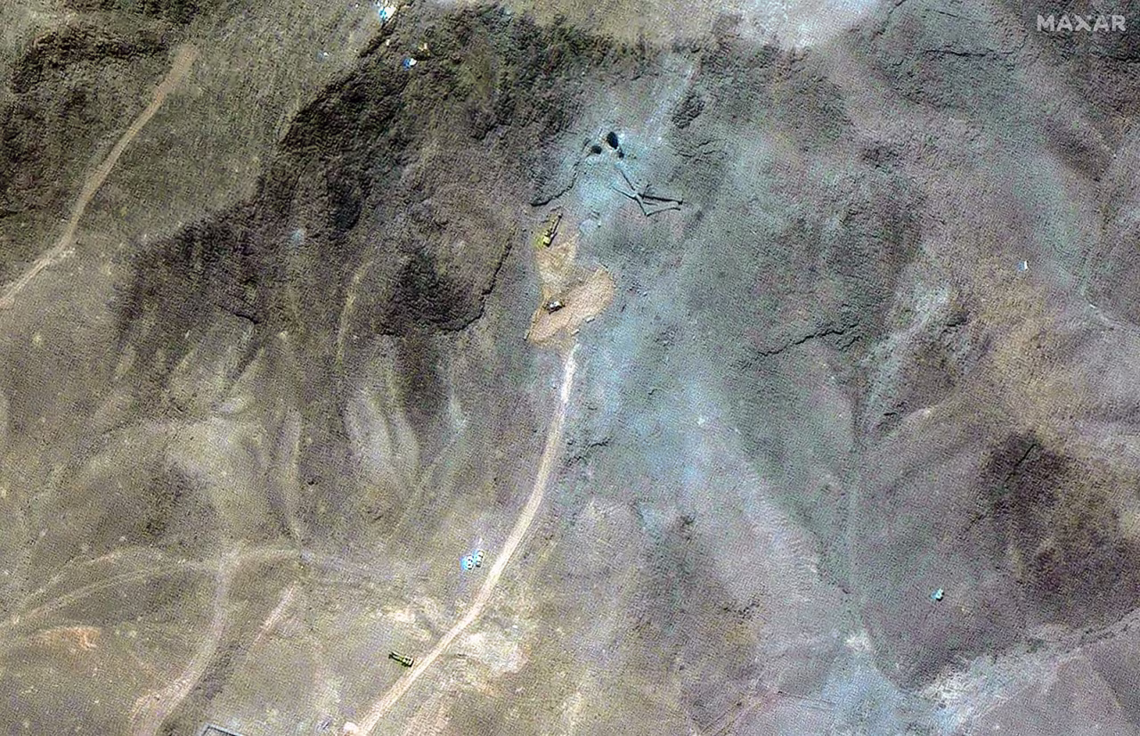 A closer view of excavators at the tunnel entrances.