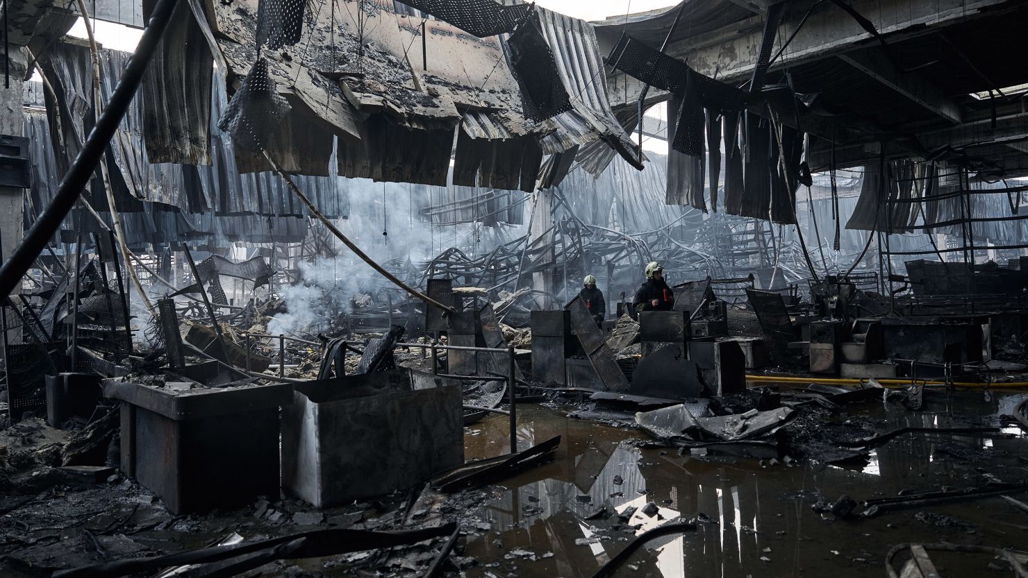 Workers search through the remains of a store destroyed by a Russian missile strike in Kharkiv, Ukraine, May 26, 2024.