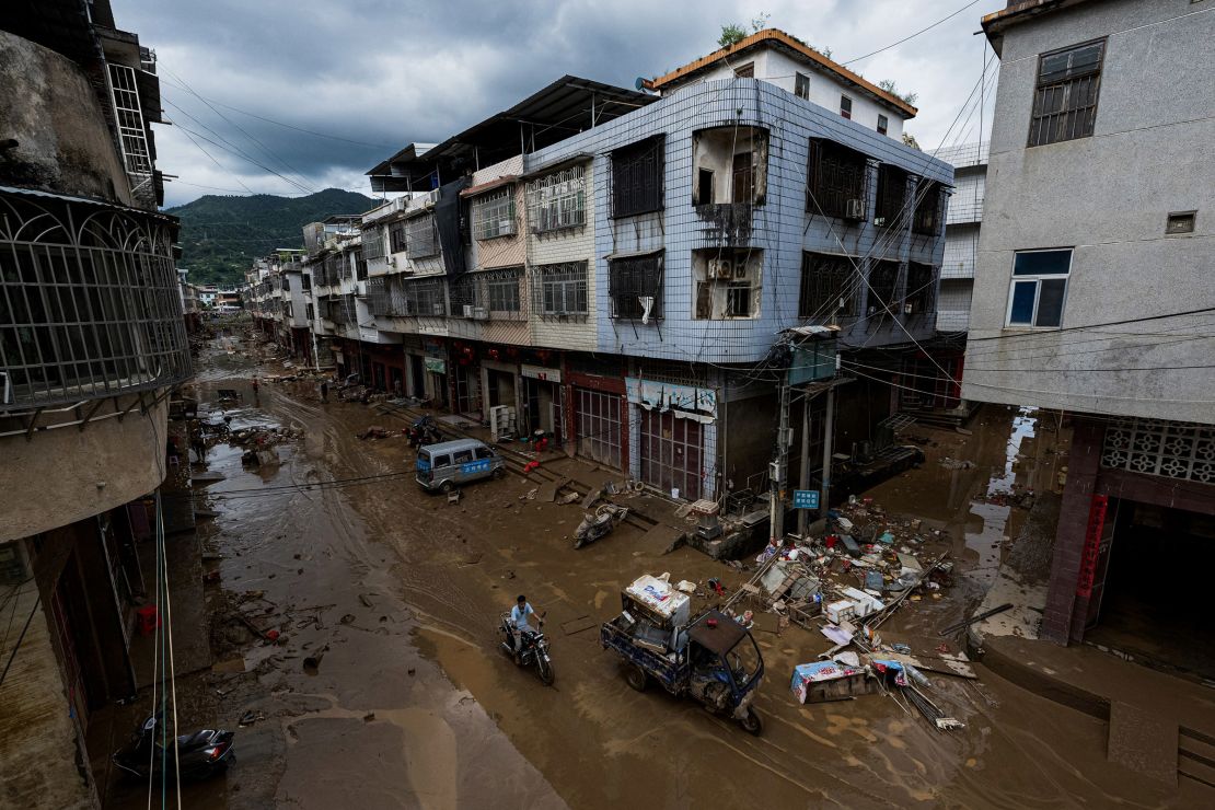 A man drives through a muddy street in the aftermath of flooding from heavy storms in Meizhou, Guangdong province last month.