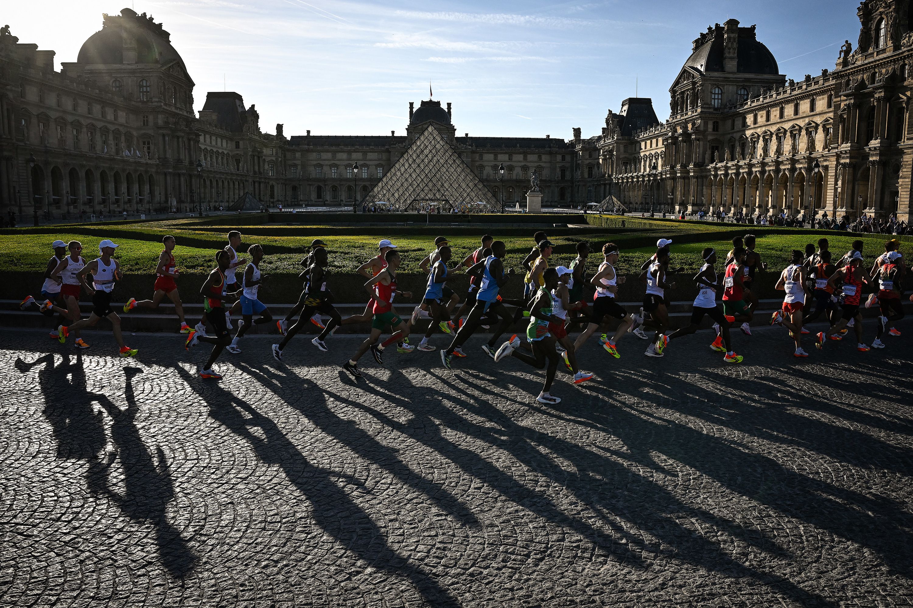 Athletes run past the Louvre Museum during the men's marathon on August 10.