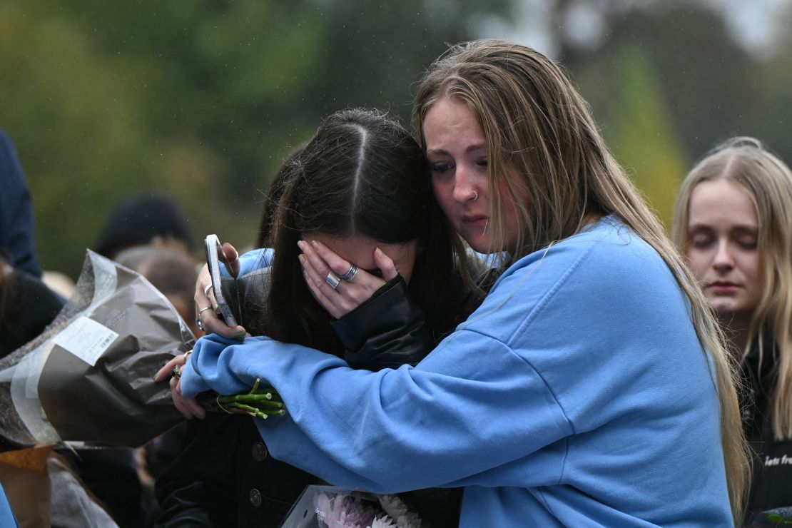 Fans comforting each other while paying tribute to Liam Payne at a memorial held on Sunday in London's Hyde Park. Justin Tallis/AFP/Getty Images