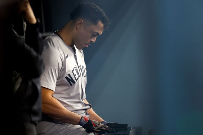 Giancarlo Stanton of the New York Yankees sits in the dugout during the eighth inning.