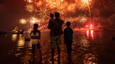 Local residents look at fireworks as they celebrate the New Year at Ancol Beach in Jakarta on January 1, 2025. (Photo by Yasuyoshi CHIBA / AFP) (Photo by YASUYOSHI CHIBA/AFP via Getty Images)