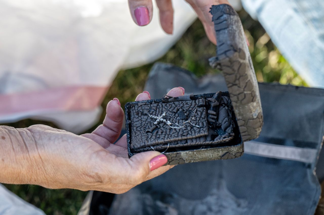 Christine Montes holds a necklace that survived the Eaton Fire as she inspects the remains of her home Thursday in Pasadena.