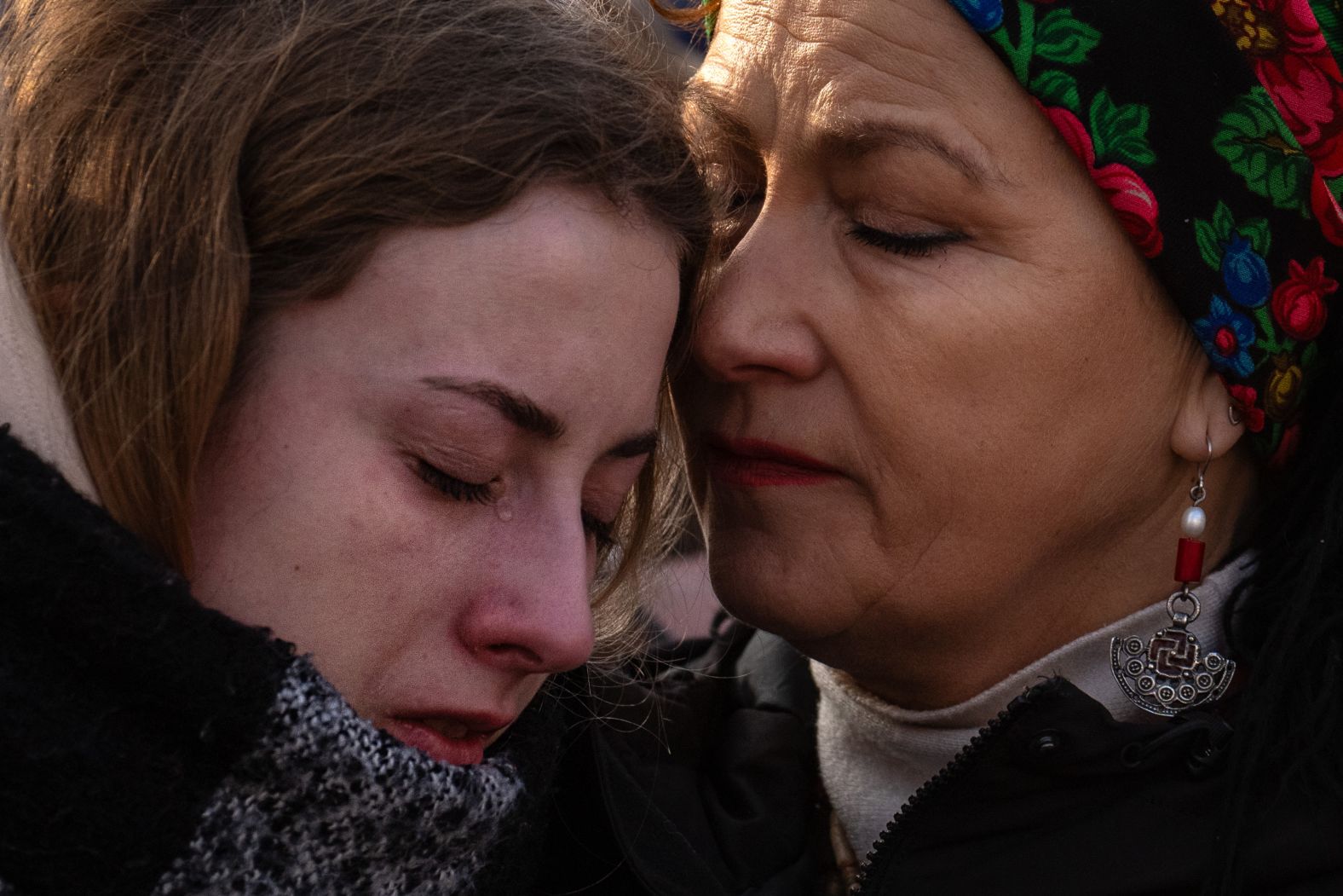 A woman comforts her daughter at the funeral for Ruslan Hanuschak in Kharkiv, Ukraine, on Saturday, January 18. Hanuschak was killed in the war with Russia.