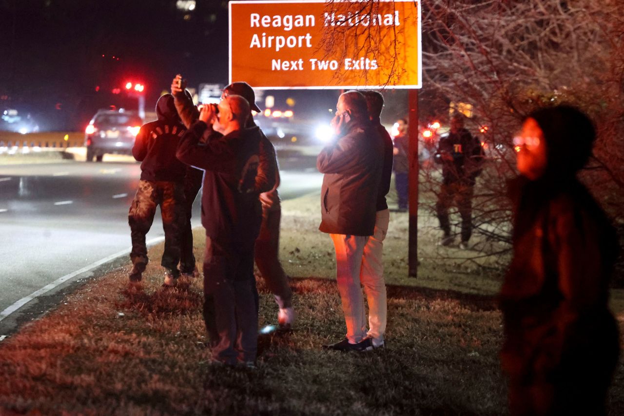 Onlookers watch as emergency crews respond to the crash site.