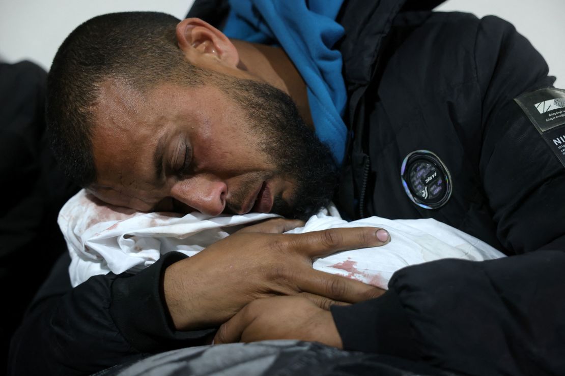 A Palestinian man hugs the body of a baby at the Indonesian Hospital in Beit Lahia, Gaza, following Israeli airstrikes in northern Gaza on Thursday.