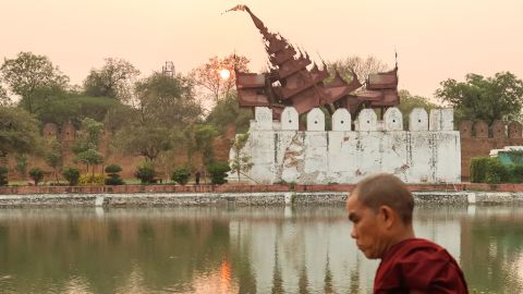 TOPSHOT - A Buddhist monk walks past the damaged Mandalay Palace during sunset in Mandalay on March 31, 2025, three days after the deadly Myanmar earthquake. Myanmar declared a week of national mourning on March 31 for the country's devastating earthquake, as the death toll passed 2,000 and hopes faded of finding more survivors in the rubble of ruined buildings. (Photo by Sebastien BERGER / AFP) (Photo by SEBASTIEN BERGER/AFP via Getty Images)          