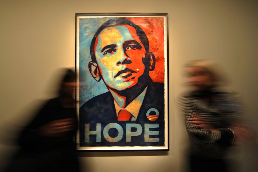 People walk past Shepard Fairey's portrait of Barack Obama at the National Portrait Gallery in Washington, DC in January 2009. The portrait came to symbolize Obama's historic campaign.