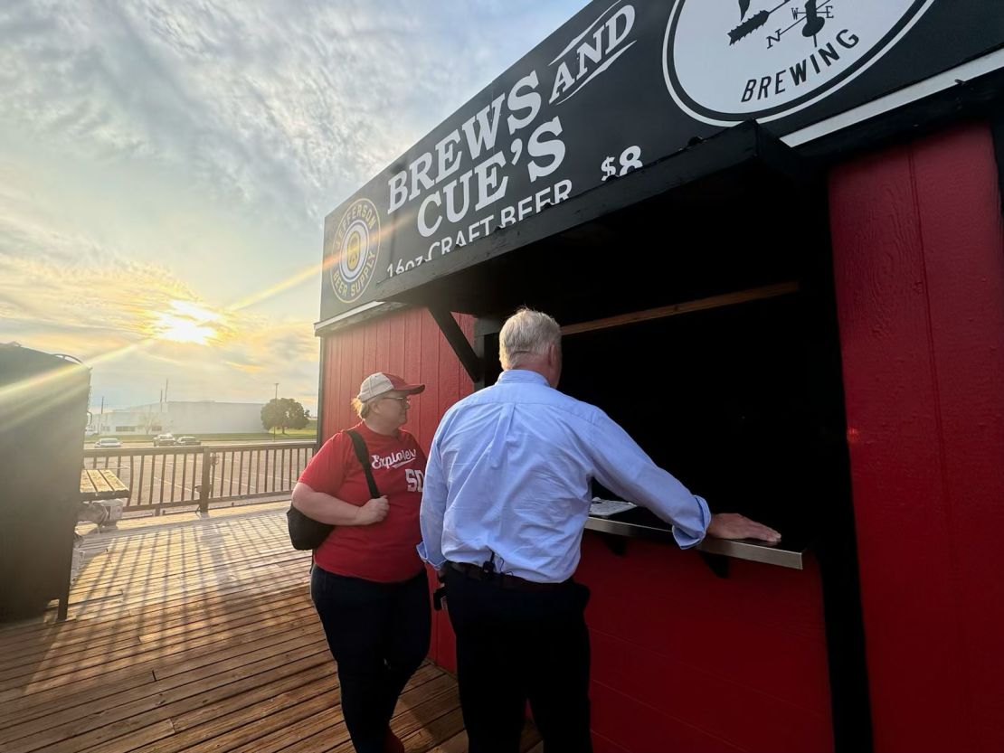 John King e a eleitora de Iowa, Priscilla Forsyth, em um jogo de beisebol em Sioux City, Iowa.