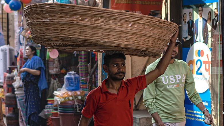 A worker carries a straw basket on the top of his head in Mumbai on April 15, 2024.