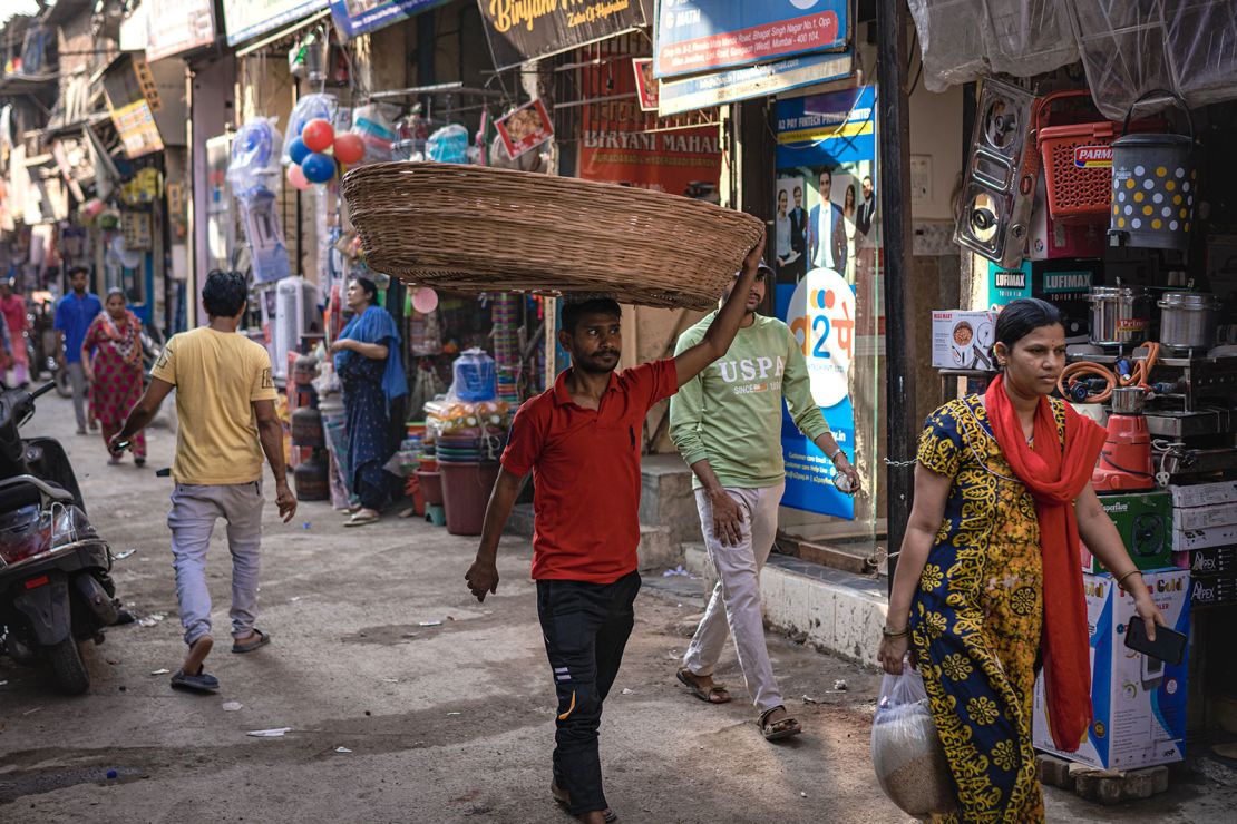 A worker balances a straw basket on his head in Mumbai on April 15, 2024.