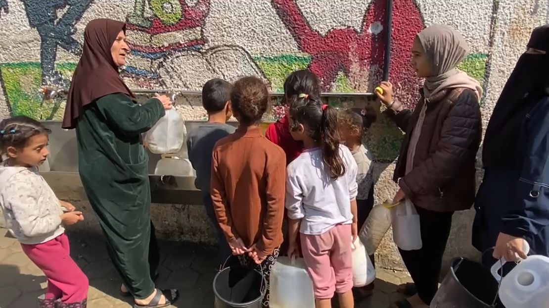 Um Ihab (second left) queues up to collect water with her grandchildren, at a displacement shelter in Deir al-Balah, in central Gaza. She told CNN that water “is very scarce."