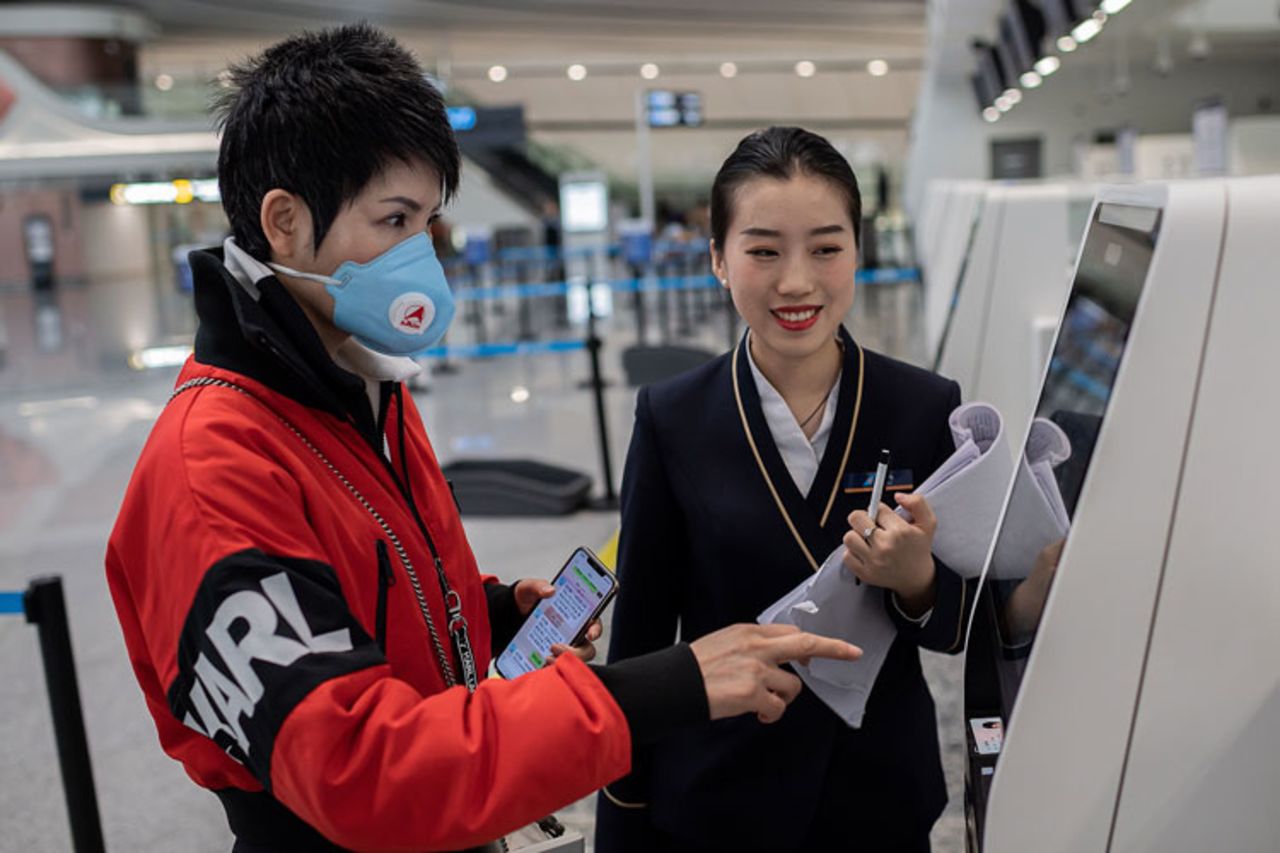 A traveller receives check-in assistance from airline staff at the Daxing International Airport. 