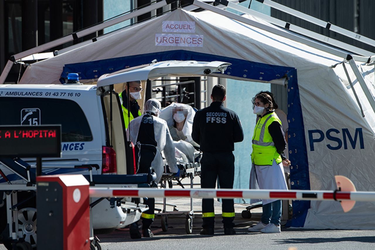 Doctors tend to a patient arriving on a wheelchair at tent set up in a courtyard of the Henri Mondor Hospital in Creteil, France, on Monday, March 30.