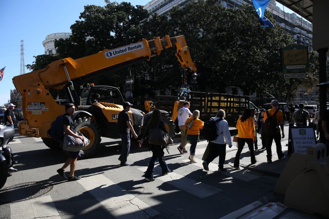 People walk along a vehicle carrying temporary barriers in New Orleans on February 2.