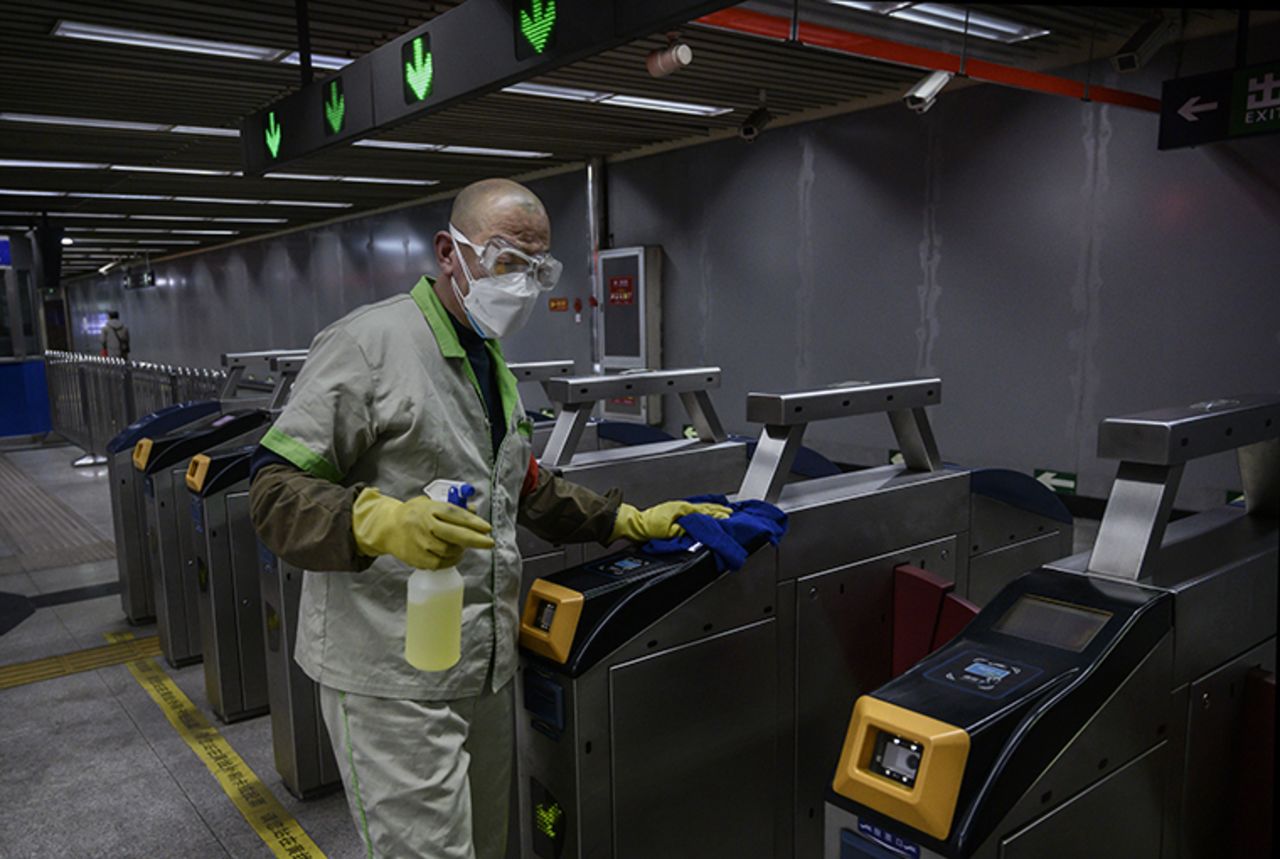 A worker wears a protective mask and goggles as he cleans and disinfects machines at a nearly empty subway station during rush hour on Friday, February 14, in Beijing, China.