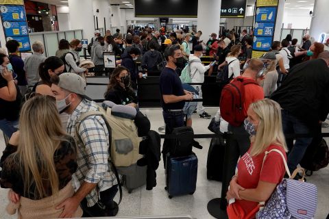 People wait in the line to clear through the TSA checkpoint at Miami International Airport on Wednesday, November 24.
