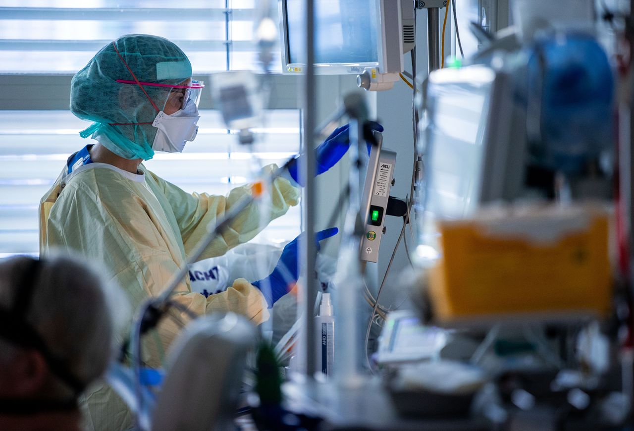 A healthcare worker documents the treatment steps in the specially protected part of the intensive care unit of the University Hospital Greifswald next to the bed of a Covid-19 patient in Mecklenburg-Western Pomerania, Greifswald, Germany, on November 23.