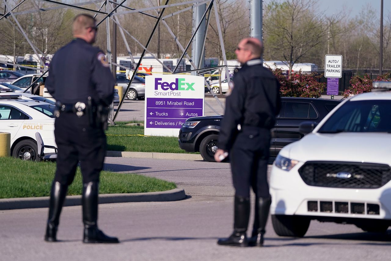 Police stand outside the Indianapolis FedEx facility on Friday morning.