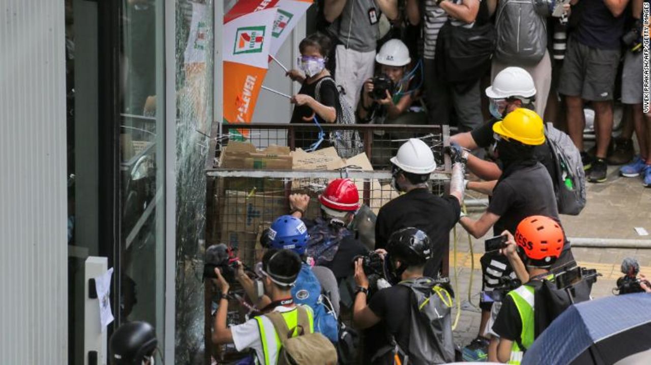 Protesters ram a metal cart into a window at the Legislative Council building.