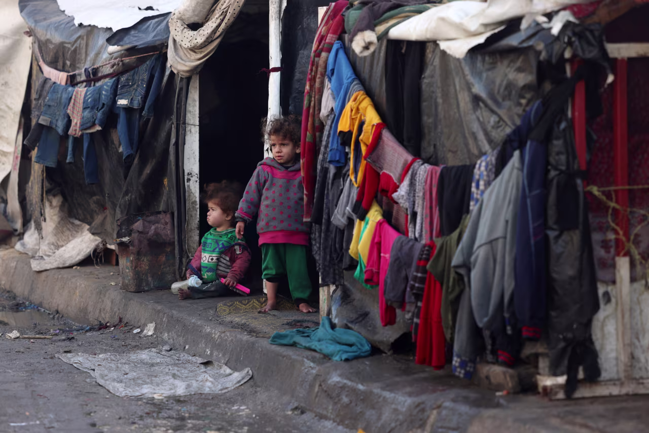 Children stand outside tents at a makeshift tent camp housing displaced Palestinians in Rafah, near the border with Egypt in southern Gaza, on January 23.