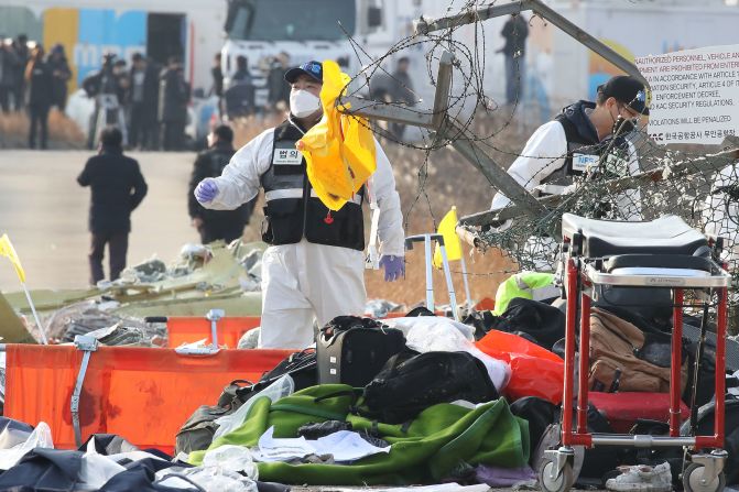 Rescue team members work near the wreckage of the plane on December 29.