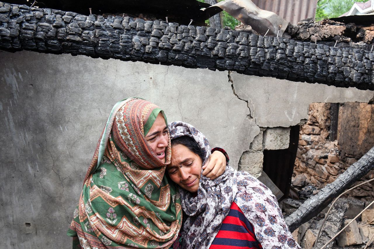 Women cry in the remains of their destroyed house in Salamabad village in Uri.