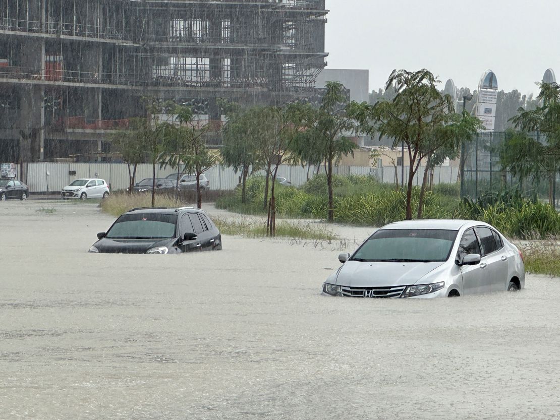 Cars drive through a flooded street during a rainstorm in Dubai.