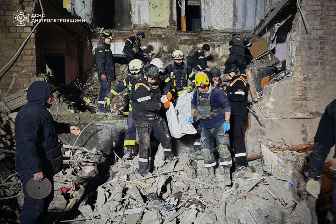 Rescuers carry Olena's body out of the rubble.